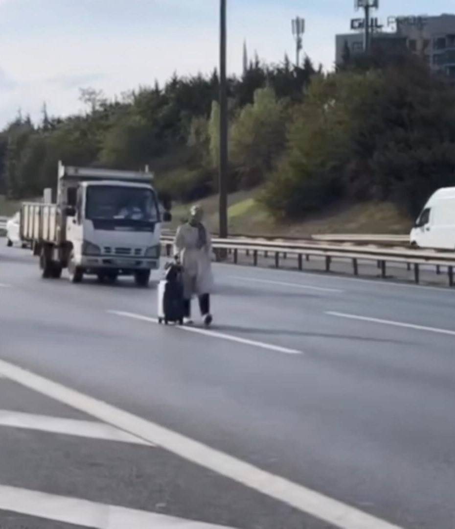 Elinde bavuluyla trafiğin ortasında yürüdü